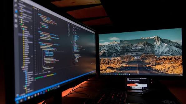 IT technician troubleshooting computer system errors and data recovery on a dual monitor workstation